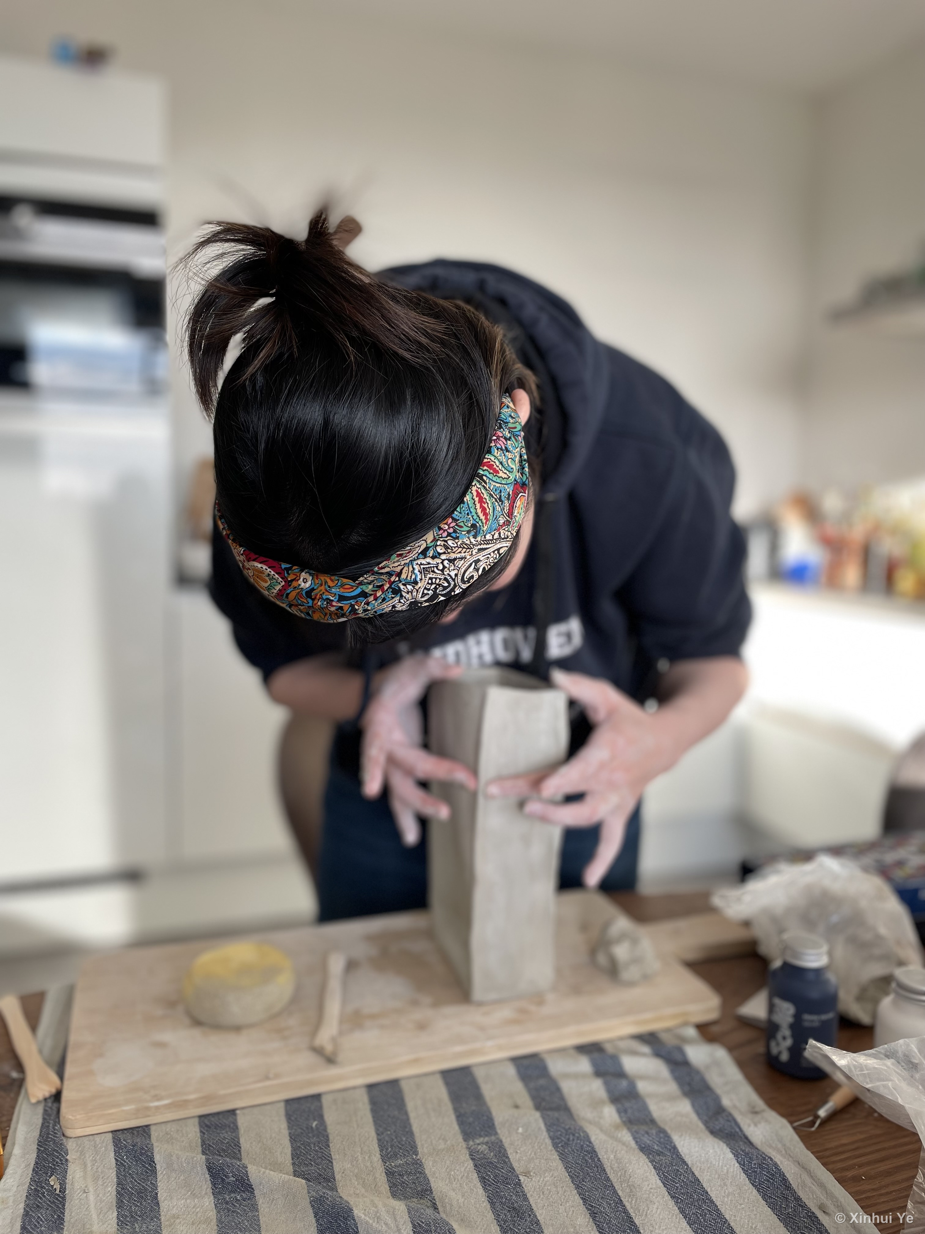 Xinhui shaping a clay vessel